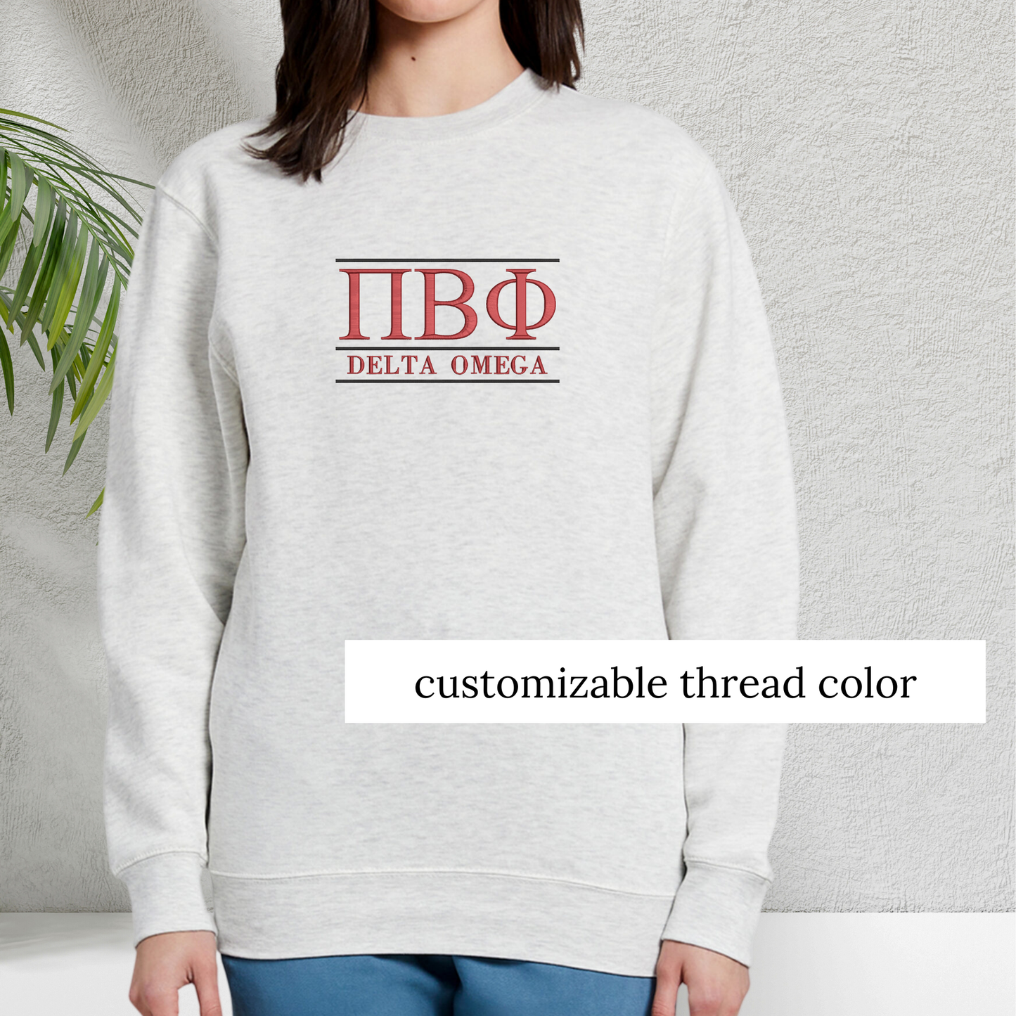 Light grey sweatshirt featuring simple sorority letters and the sorority chapter on the chest, highlighted in red to indicate which areas of the design can be customized, set against a minimalistic background.