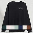 Load image into Gallery viewer, A black sweatshirt laid flat, showing sorority letters embroidered in white on the chest. Below, a swatch palette of available sweatshirt colors including forest, pale pink, seafoam, navy, chestnut, grey, cream, and black is visible.
