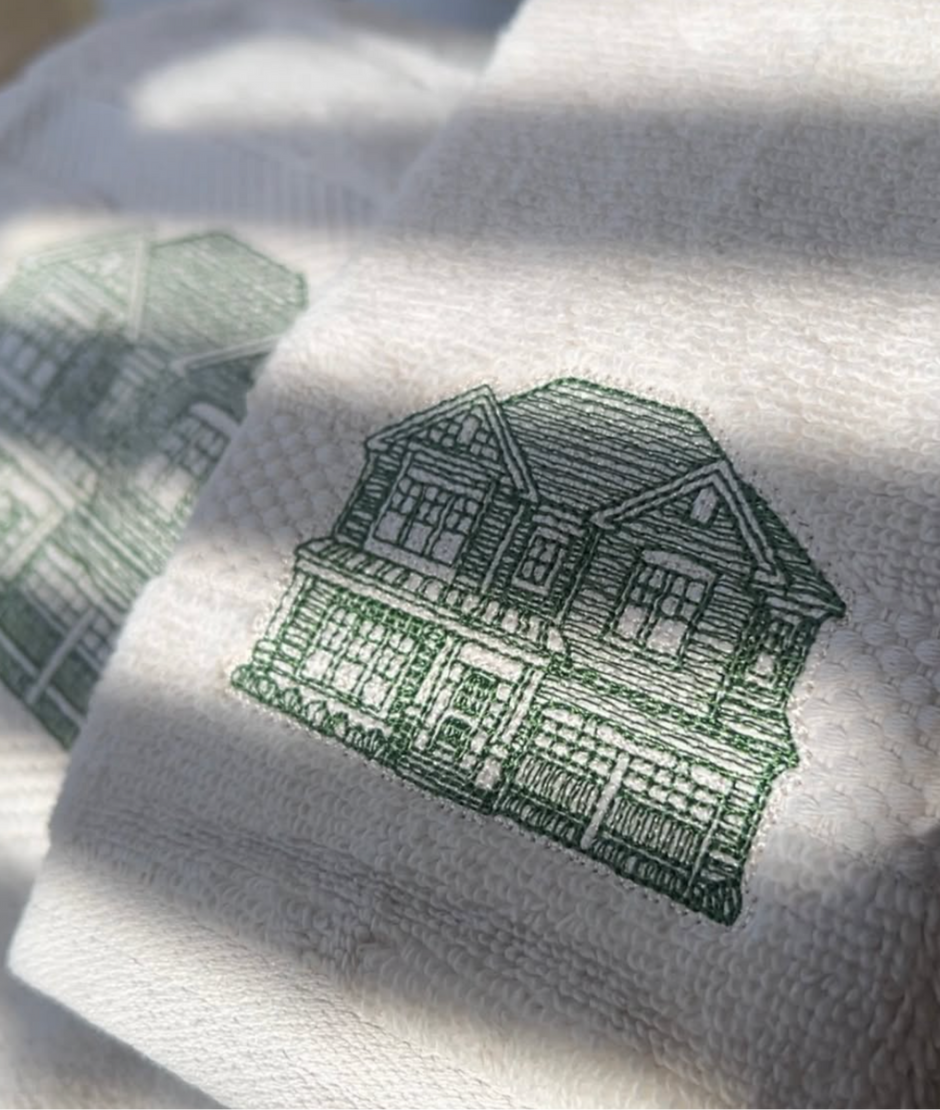 Cream towels with green house embroidery 